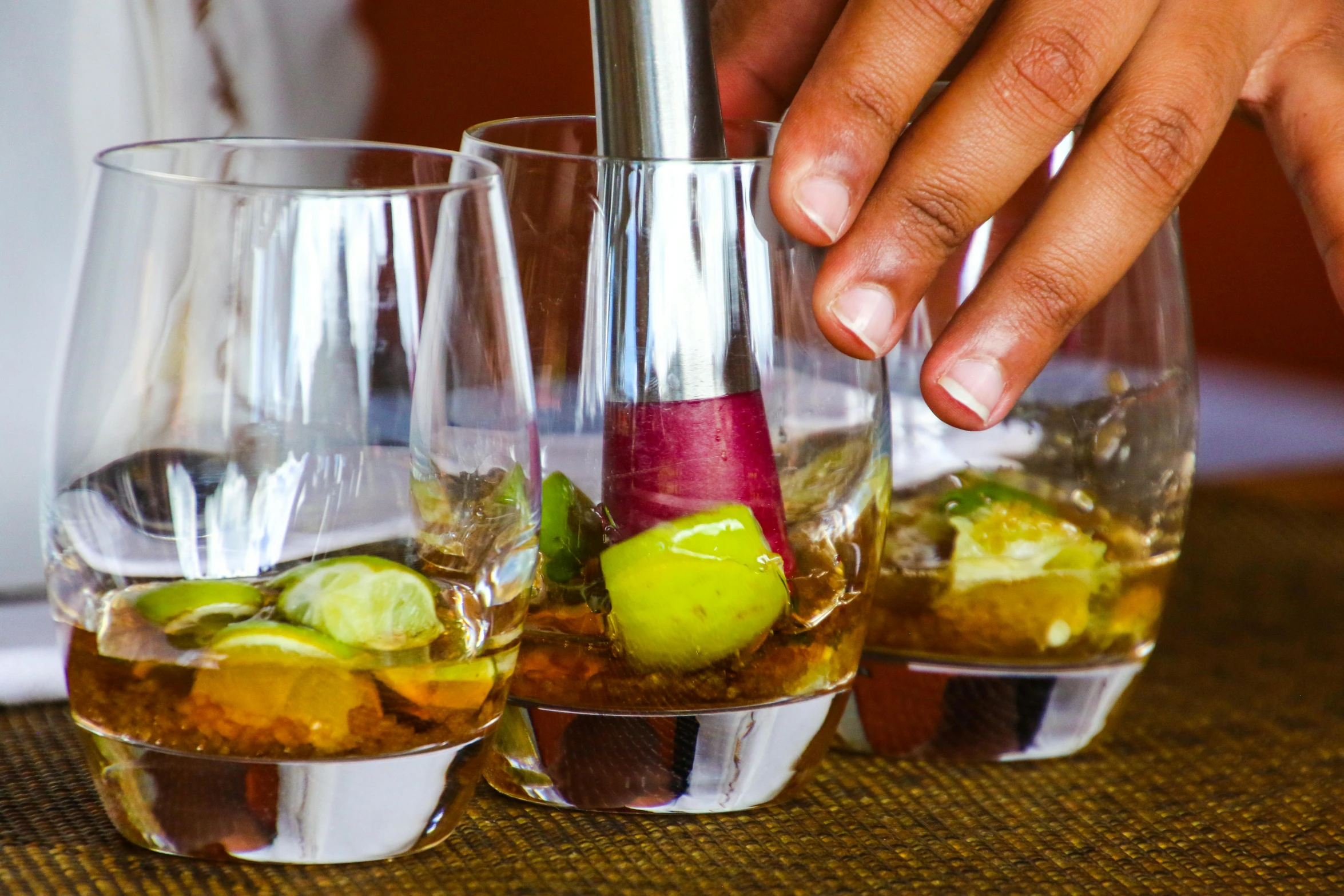 a close up of two glasses of alcohol on a table, by Julia Pishtar, pexels, process art, jamaica, partially cupping her hands, lime and violet, in a row