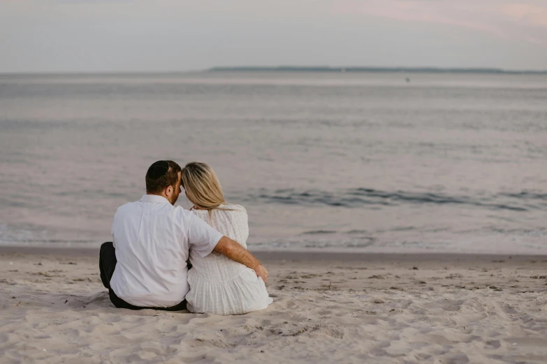 a man and a woman sitting next to each other on a beach, a picture, by Emma Andijewska, pexels contest winner, romantic lead, white, low detailed, hziulquoigmnzhah