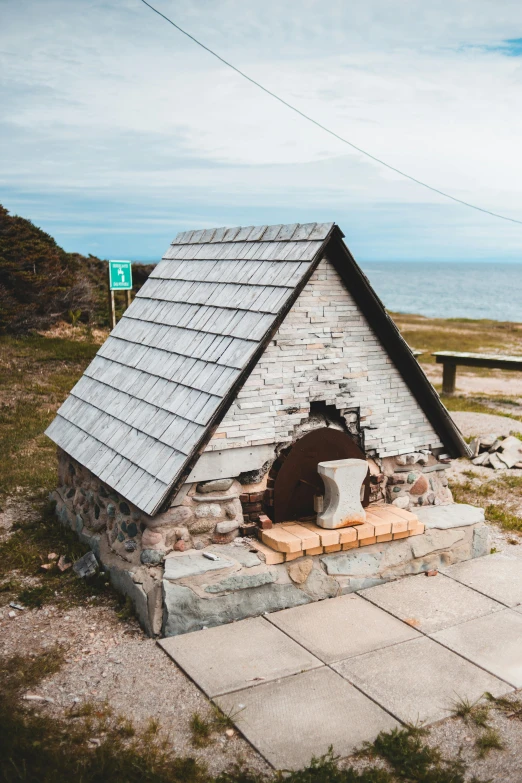 a stone oven sitting on the side of a road, a statue, by Franz Hegi, unsplash, built around ocean, hut, replica model, marble hole