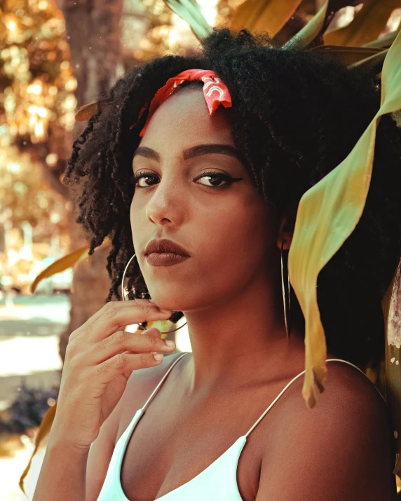 a woman with a flower in her hair, by Lily Delissa Joseph, trending on unsplash, she has olive brown skin, wearing a headband, female camila mendes, ethiopian