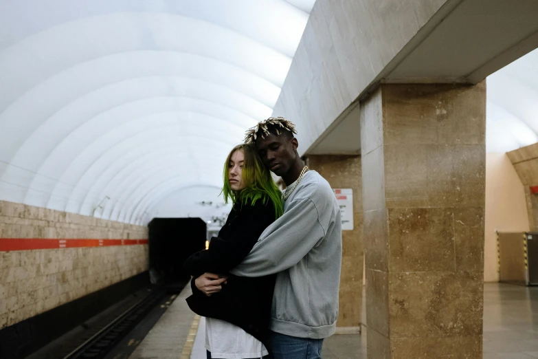 a man and a woman hugging in a subway station, an album cover, by Emma Andijewska, pexels contest winner, bright green hair, virgil abloh, high quality wallpaper, 268435456k film