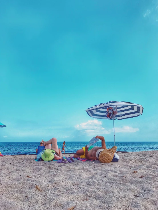 a group of people laying on top of a sandy beach, single person with umbrella, profile image, sunbathed skin, children's