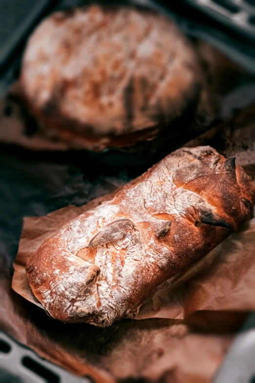 a loaf of bread sitting inside of an oven, by Adam Marczyński, pexels contest winner, renaissance, parchment paper, close up food photography, thumbnail, sparkling