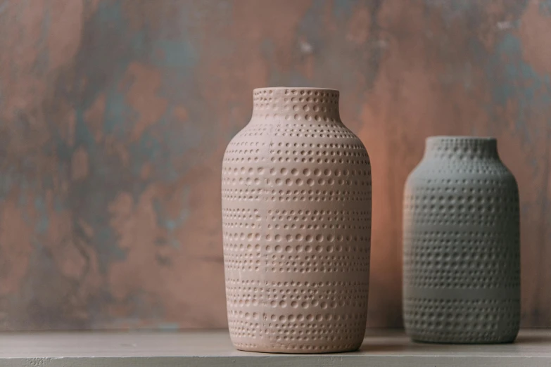a couple of vases sitting on top of a table, inspired by Hendrik Gerritsz Pot, kinetic pointillism, pastel pink concrete, brick, medium close shot, bottle