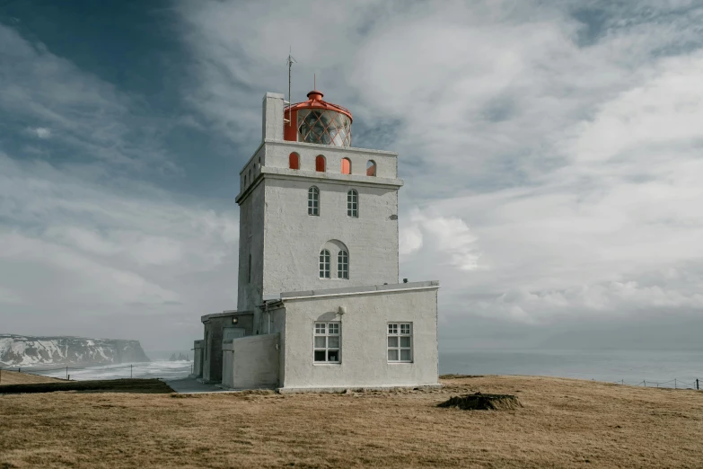 a white and red lighthouse sitting on top of a hill, by Jesper Knudsen, pexels contest winner, big windows, grey, medium format color photography, searchlight