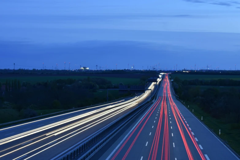 a highway filled with lots of traffic at night, a picture, by Werner Gutzeit, unsplash, blue hour, plain background, lines of energy, photographed for reuters