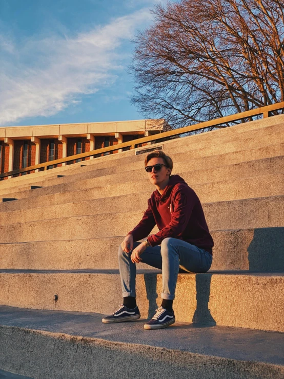 a man sitting on some steps with a skateboard, by Niko Henrichon, maroon, soccer player martin ødegaard, profile image, iphone photo