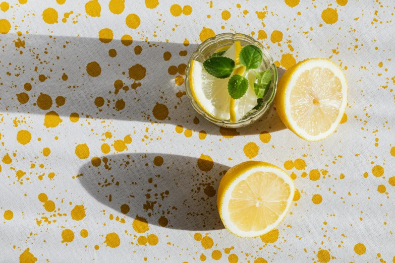 a glass of lemonade sitting on top of a table, inspired by Sigmar Polke, trending on unsplash, visual art, overhead sun, subtle pattern, 🐿🍸🍋, light scatter