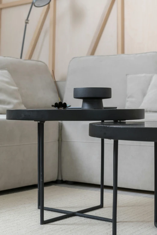 a black coffee table sitting on top of a white couch, by Jan Tengnagel, kinetic art, all black matte product, subwoofer, medium close up shot, random circular platforms