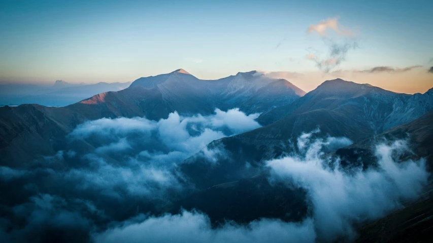 a view of a mountain range with clouds in the foreground, by Peter Churcher, pexels contest winner, baroque, lit from above, lachlan bailey, amanda lilleston, conde nast traveler photo