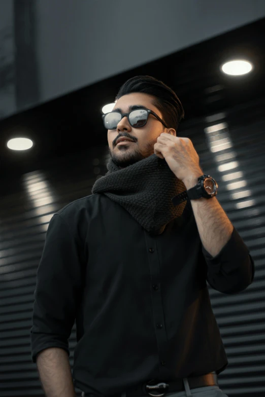 a man in a black shirt talking on a cell phone, trending on pexels, hurufiyya, sunglasses and a scarf, high fashion themed, man wearing a closed cowl, lights on