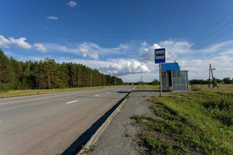 a street sign sitting on the side of a road, by Anato Finnstark, velly distant forest, soviet bus stop, blue sky, фото девушка курит