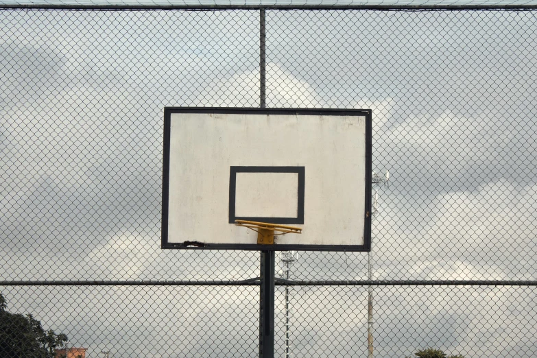 a basketball hoop in front of a chain link fence, by Carey Morris, square, schools, no people 4k, uniform off - white sky