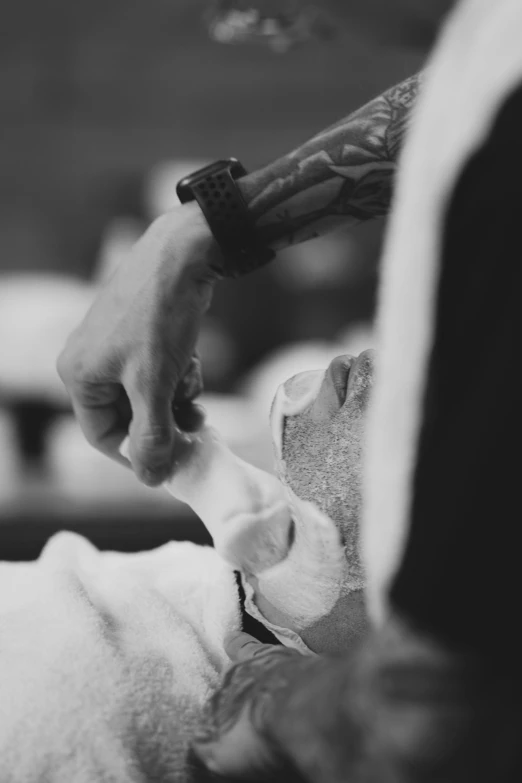 a black and white photo of a man getting his hair cut, pexels contest winner, process art, hand holding a knife, shaven stubble, soap carving, lachlan bailey