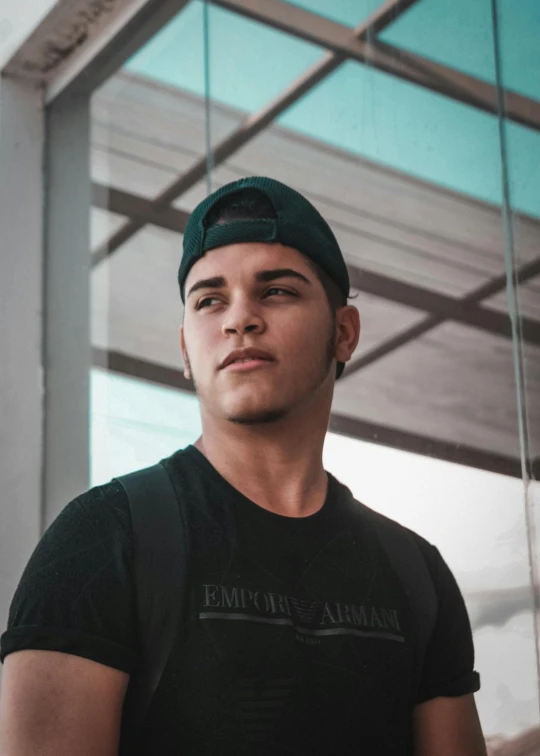 a man in a black shirt and a green hat, by Alejandro Obregón, reddit, discord profile picture, são paulo, slightly tanned, indoor picture