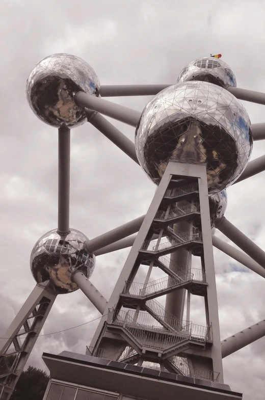 a close up of a metal structure on a cloudy day, inspired by Buckminster Fuller, nuclear art, brussels, disco balls, turbines, martian architecture