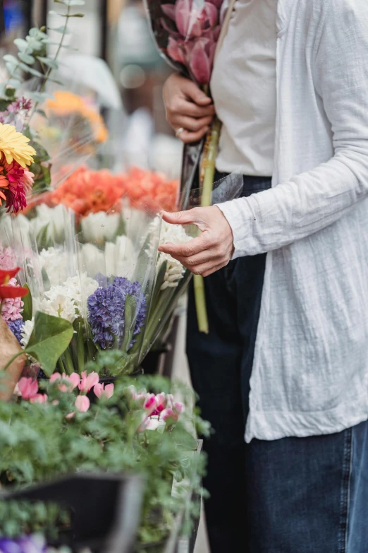 a woman standing next to a man holding a bunch of flowers, by Niko Henrichon, trending on unsplash, arts and crafts movement, colored market stand, loosely cropped, walking down, organic detail