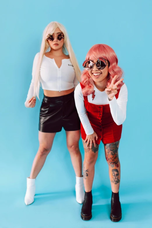 two women standing next to each other on a blue background, an album cover, trending on pexels, kitsch movement, wearing red tainted glasses, bra and shorts streetwear, crazy white hair, cosplay photo