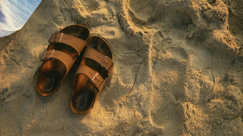 a pair of sandals sitting on top of a sandy beach, unsplash, hyperrealism, birkenstock sandals, muted browns, thumbnail, photoshopped