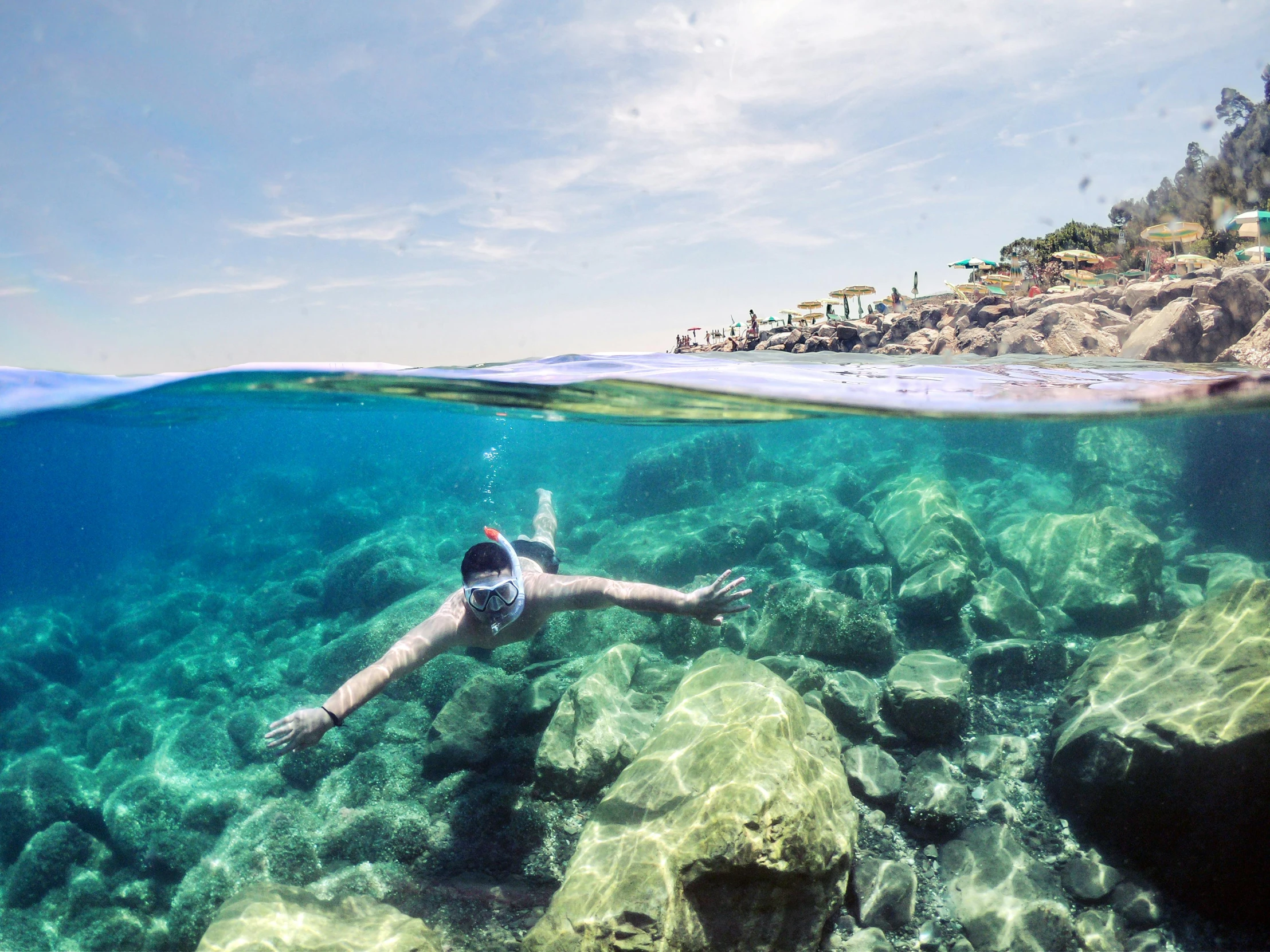 a person swimming in a body of water, reefs, clear blue water, thalassophobia, shoreline