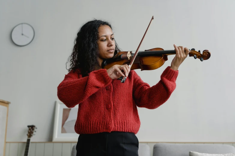 a woman in a red sweater playing a violin, pexels contest winner, arabesque, avatar image, ashteroth, medium level shot, at home