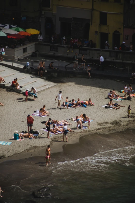 a group of people laying on top of a sandy beach, cinq terre, photo of zurich, gigapixel photo, square