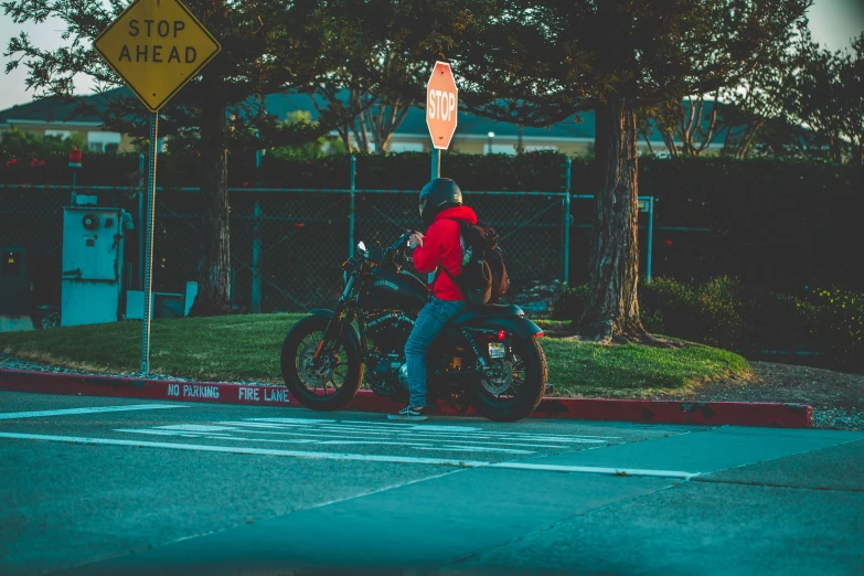 a man riding on the back of a motorcycle down a street, unsplash, realism, stop sign, high school, avatar image