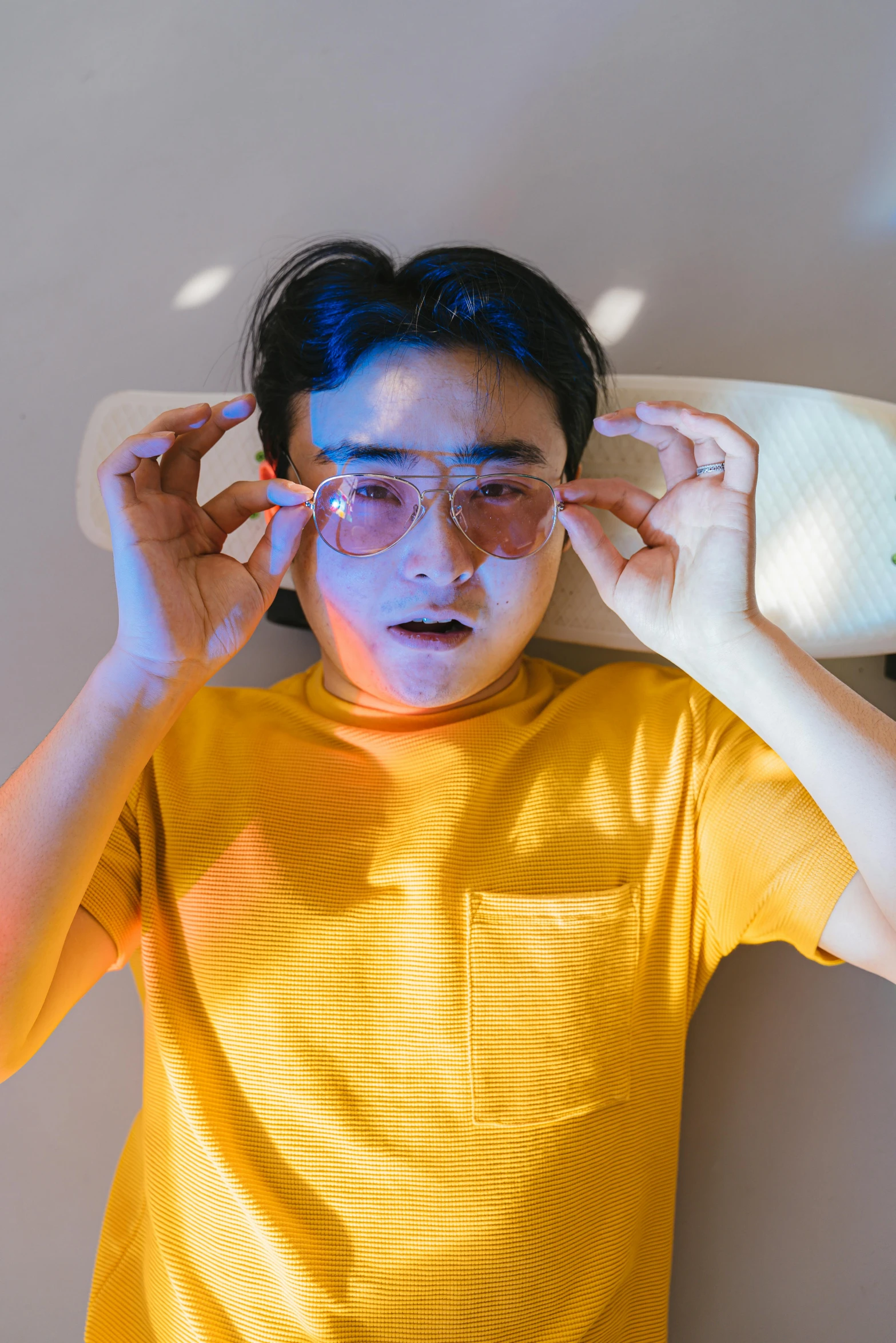 a woman in a yellow shirt holding a skateboard over her head, inspired by Ren Hang, trending on pexels, hyperrealism, he wears an eyepatch, someone sits in bed, asian man, headshot profile picture