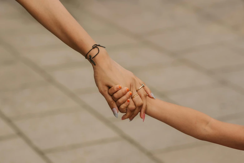 a close up of a person holding a child's hand, trending on pexels, woman holding another woman, all around, animation, wearing two silver bracelets