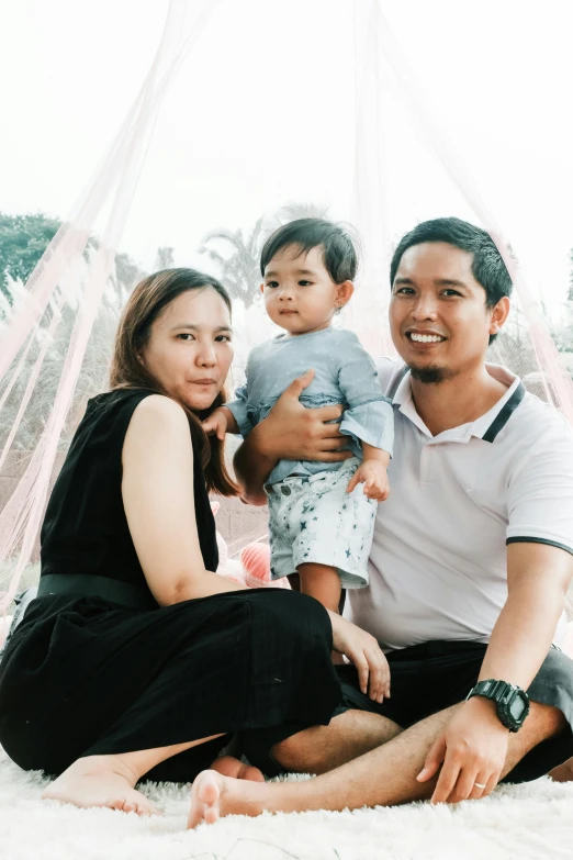 a man and woman pose for a picture with a baby, a picture, by Yosa Buson, pexels contest winner, happening, low quality photo, bowater charlie and brom gerald, 2 years old, attractive photo