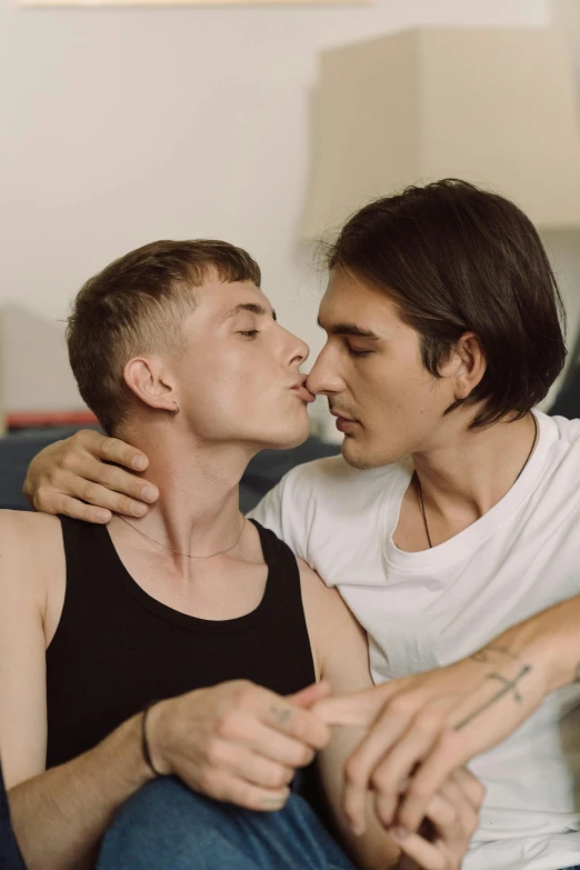 a couple of men sitting on top of a couch, by Cosmo Alexander, trending on pexels, romanticism, lesbian kiss, headshot, twink, official screenshot