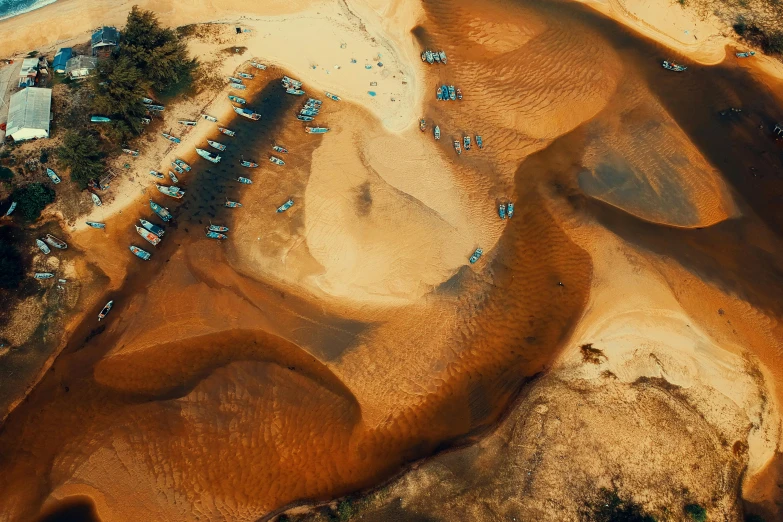 an aerial view of a sandy beach next to the ocean, by Adam Marczyński, unsplash contest winner, land art, spaceship in a dry river bed, boats in the water, thumbnail, sahara