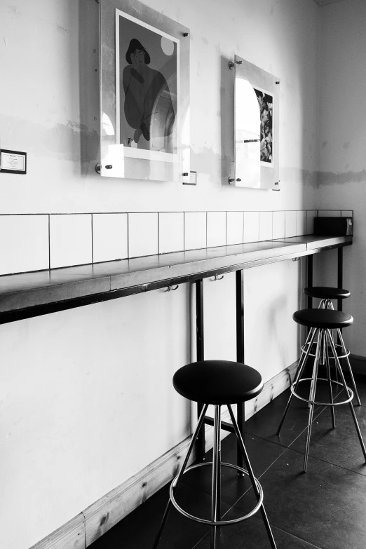 a black and white photo of a bar with stools, a black and white photo, postminimalism, art station, ( ( photograph ) ), three, featured