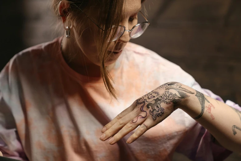 a woman with a tattoo on her arm, trending on pexels, emanating magic from her palms, with a tentacle tattoo, aged 2 5, sydney hanson