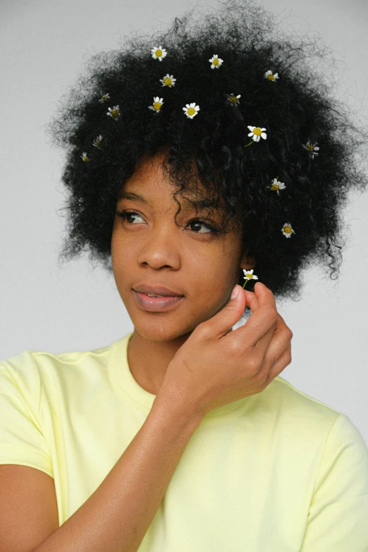 a woman with a bunch of flowers in her hair, trending on pexels, yellow gemstones, with afro, chamomile, promotional image