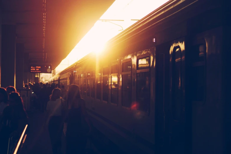 a group of people standing next to a train, unsplash, ambient amber light, instagram picture, flares, 2263539546]