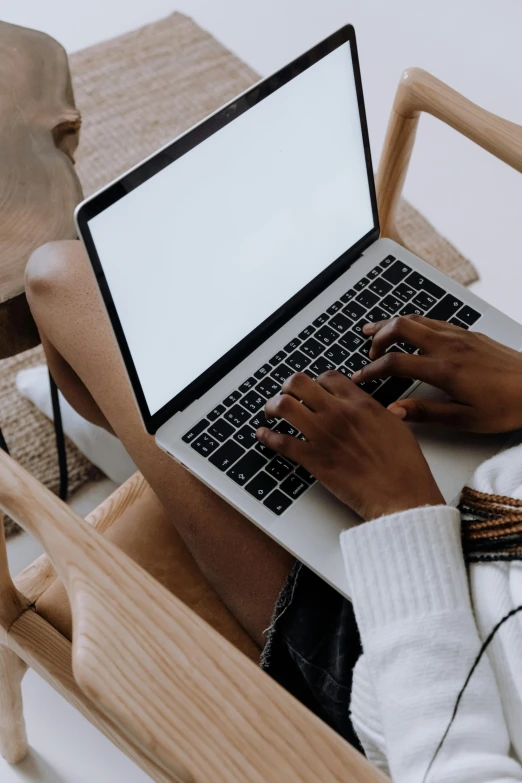 a woman sitting in a chair using a laptop computer, trending on pexels, top down shot, carefully crafted, diverse, centered in image