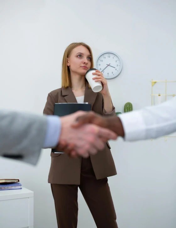 a woman shaking hands with a man in a suit, a picture, by Arabella Rankin, pexels contest winner, upset the coffee does not work, in a foggy office, photo of young woman, high quality topical render