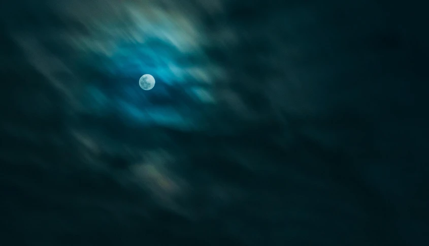 a full moon is seen through the clouds, an album cover, by Andrew Geddes, pexels contest winner, minimalism, blue blurred, ☁🌪🌙👩🏾, 8k 50mm iso 10, dark moody