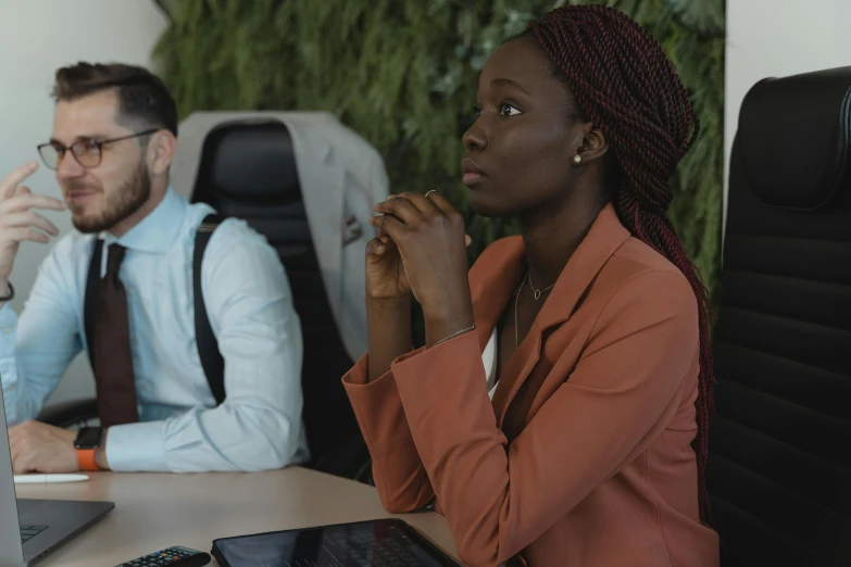 a couple of people sitting at a table with a laptop, adut akech, background image, serious business, woman with braided brown hair