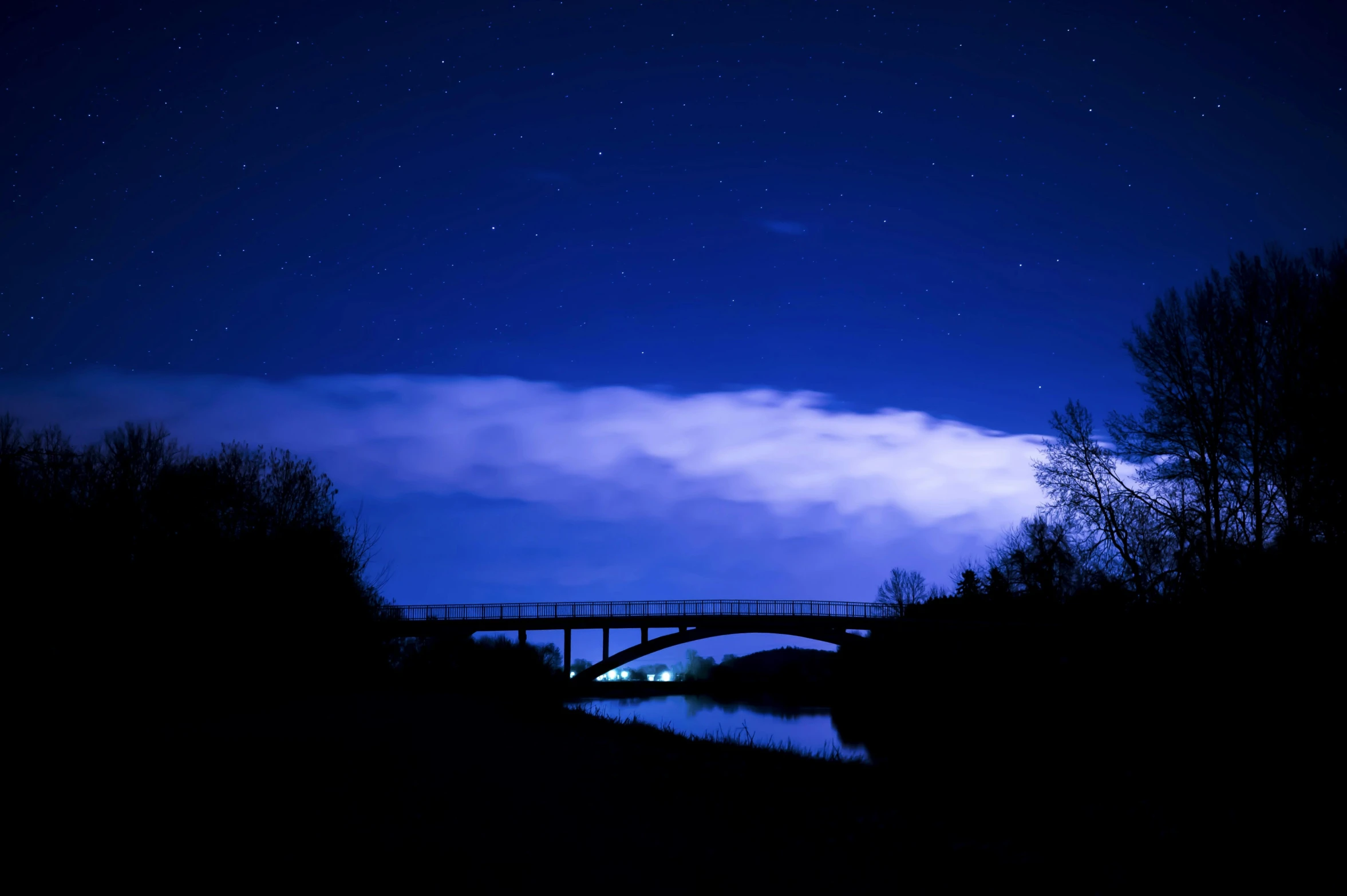 a bridge over a body of water under a night sky, by Ian Fairweather, light cloud, 2022 photograph, blue, shot on sony a 7