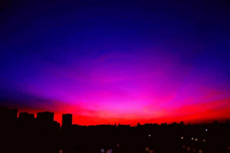the sun is setting over the city skyline, by Amelia Peláez, hurufiyya, blue and red tones, purple sunset, colorful”, night time photograph