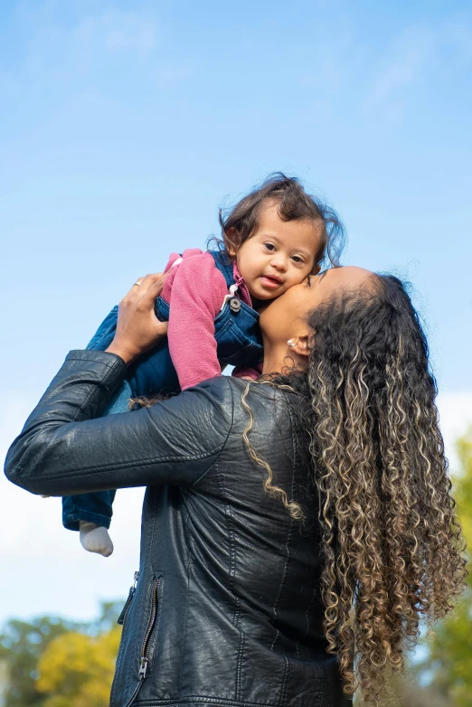 a woman holding a little girl in her arms, by Washington Allston, pexels, clear blue skies, an olive skinned, square, coloured