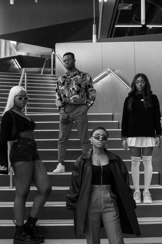 a group of people standing on a set of stairs, an album cover, by Charles Martin, unsplash, realism, black skin!!!, young women, black white, serious