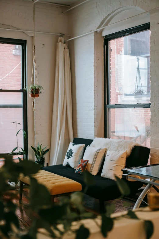 a living room filled with furniture and lots of windows, unsplash contest winner, lush brooklyn urban landscaping, relaxing on a couch, low quality photo, black windows