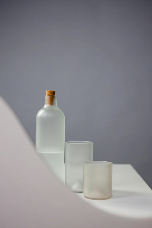 a couple of bottles sitting on top of a table, a still life, by Harvey Quaytman, trending on unsplash, minimalism, frosted glass, section model, full product shot, on a pale background