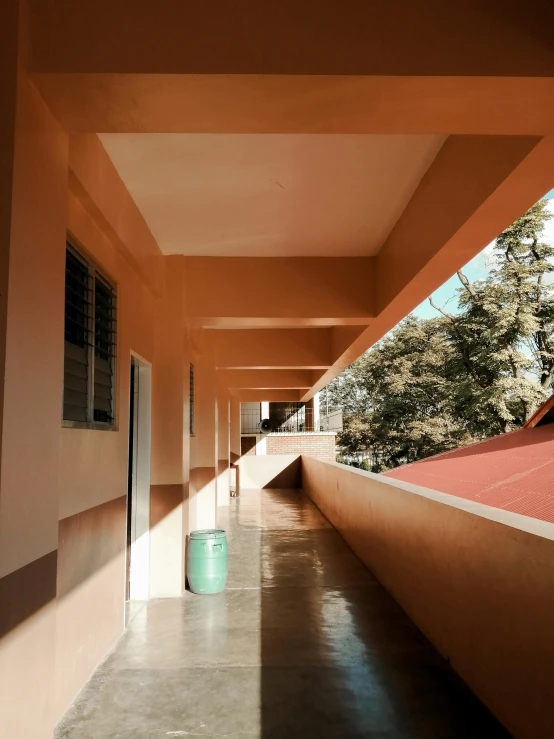 a long hallway leading to a building with a red roof, by Anna Haifisch, quito school, morning light, well shaded, a high angle shot, water running down the walls