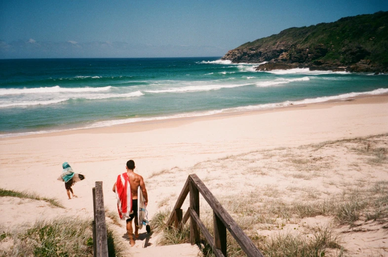 a man carrying a surfboard down a set of stairs, by Lee Loughridge, pexels contest winner, beach is between the two valleys, boys, kombi, people walking around