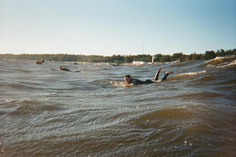 a man riding a wave on top of a surfboard, helsinki, gofl course and swimming, wide river and lake, beaching