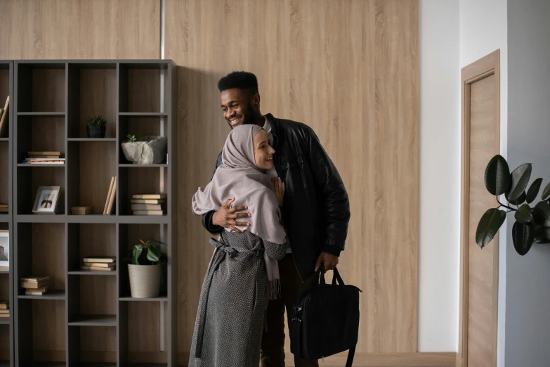 a man and woman hugging each other in a living room, pexels contest winner, hurufiyya, exiting from a wardrobe, muslim, black man, handsome